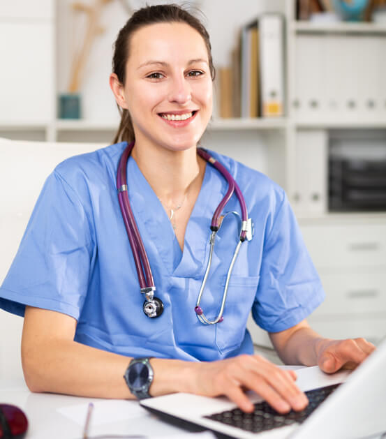 Request an Appointment doctor smiling next to her laptop